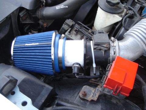 1998 Lincoln Town Car - Close-up of a blue performance air filter installed in an engine bay.