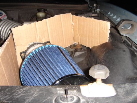 1998 Lincoln Town Car - Aftermarket air filter installed in engine bay, partially covered by cardboard.