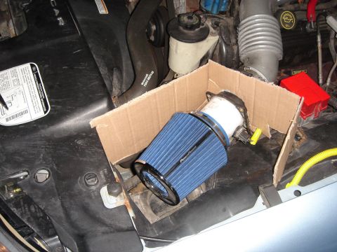 1998 Lincoln Town Car - An aftermarket air filter is placed in a cardboard box within the engine bay.