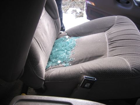 1995 Ford Bronco - Shattered glass litters the driver's seat of a vehicle, indicating a broken window.