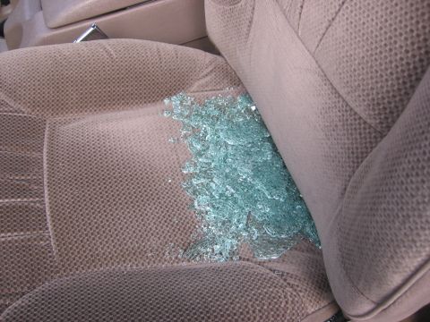 1995 Ford Bronco - Shattered glass is scattered across the fabric seat of a vehicle.