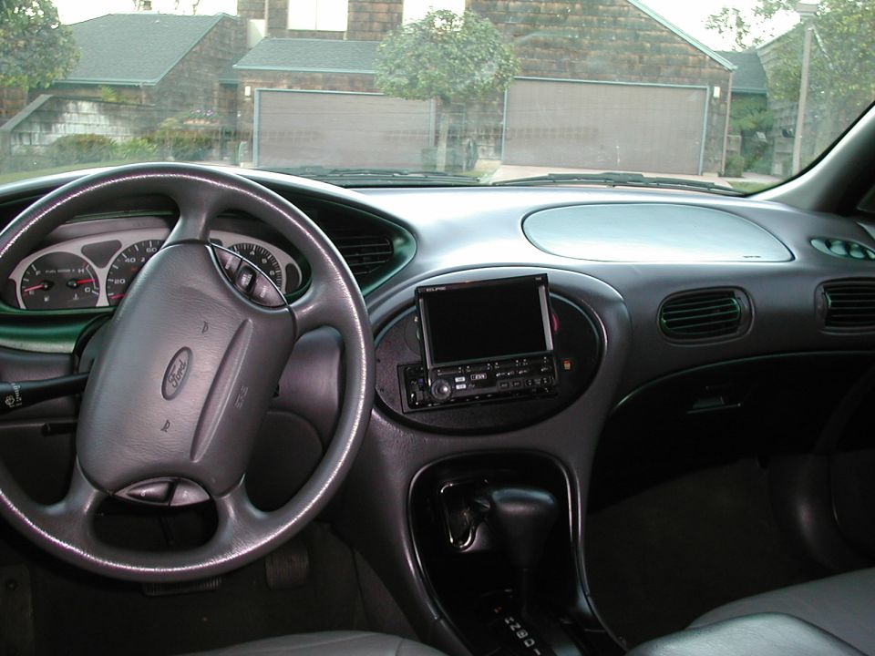 Ford sedan interior dash with Alpine head unit, green trim accents and leather steering wheel