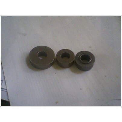 1972 Ford Ranchero - Three metal bushings are laid out on a surface, possibly for a transmission rebuild.