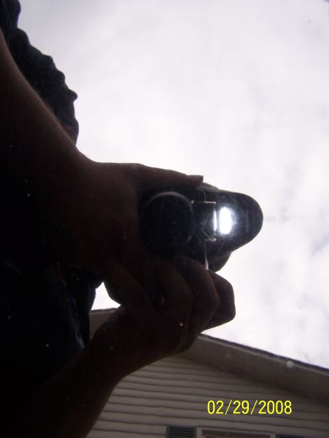 1979 Ford F-150 - A person's hands are visible holding a camera, with a bright light reflecting from its lens. The image is dated 02/29/2008.