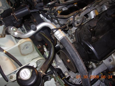 1995 Ford Taurus - Close-up view of a car's engine compartment, showing various mechanical components and hoses.