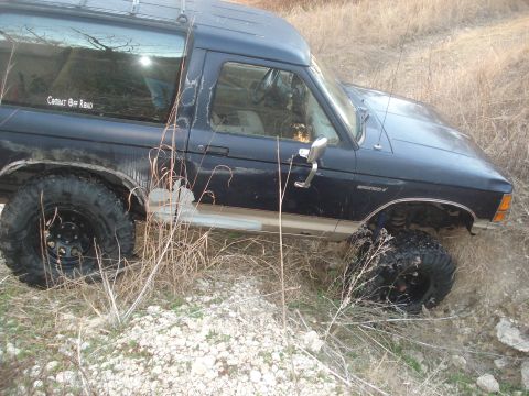 1989 Ford Bronco II - Ford Bronco II navigating rough terrain, showing off its off-road capabilities and tires.