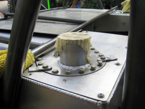 1995 Ford Bronco - Close-up of a fuel tank filler neck, covered with tape, bolted to a metal surface.