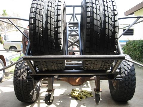 1995 Ford Bronco - This custom off-road vehicle features a robust rear-mounted spare tire carrier with two large tires.