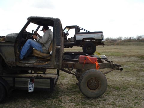 2008 International School Bus - Two trucks are visible, one loaded onto a trailer carrying another truck.