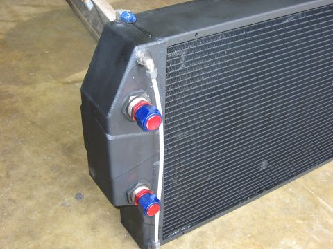 1995 Ford Bronco - This is a radiator with fittings for fluid lines, likely for an engine cooling system.