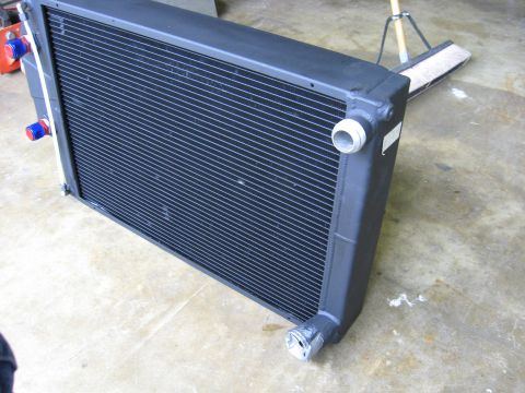 1995 Ford Bronco - A black radiator is shown from a 3/4 front angle, resting on a concrete floor.