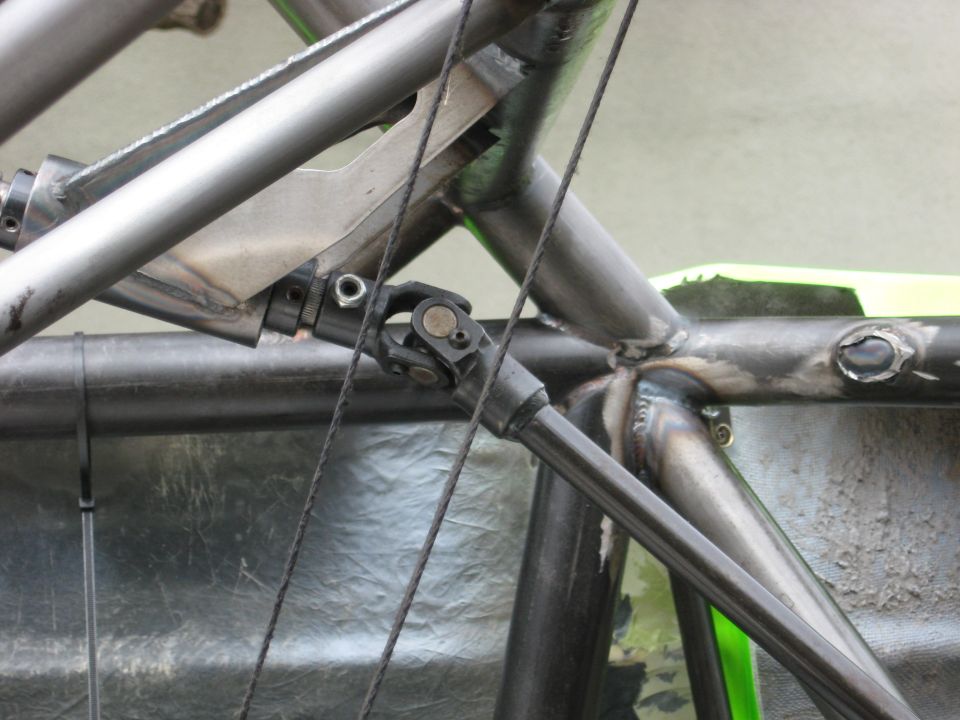 Close-up of a custom off-road vehicle's metal frame and driveshaft