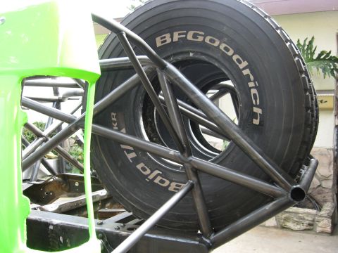 1995 Ford Bronco - Spare tire with BFGoodrich Baja T/A text mounted on a roll cage.