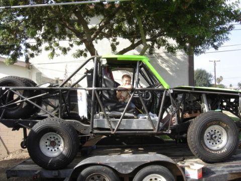 1995 Ford Bronco - A child sits in the driver's seat of a heavily modified buggy, which appears to be a custom build rather than a stock vehicle.