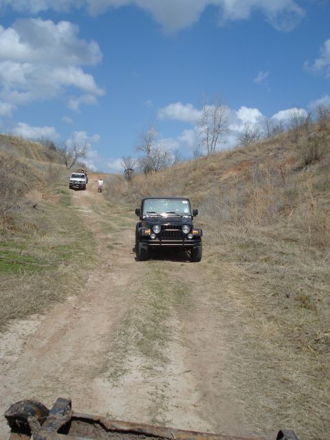 2008 International School Bus - Two Jeeps navigate a dusty trail under a partly cloudy sky.