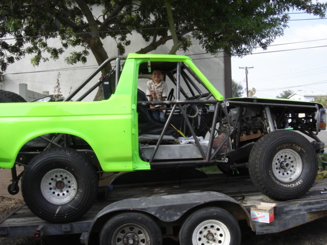 Lime green 1995 Ford Bronco race truck with exposed engine and roll cage