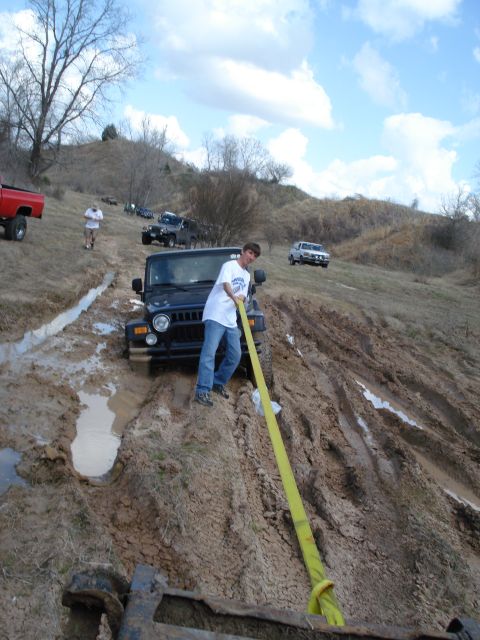 2008 International School Bus - A group of off-road vehicles navigate a muddy terrain, challenging terrain.
