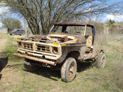 2008 International School Bus - This weathered pickup truck sits abandoned in a grassy field, its engine exposed and body showing significant wear.