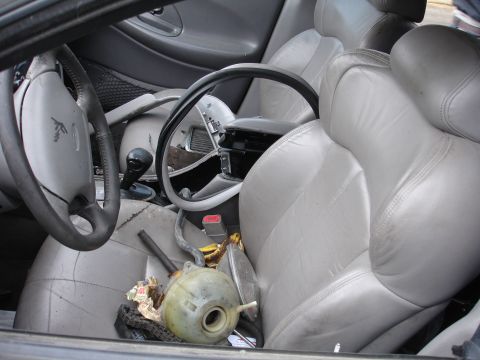1993 Ford Taurus - Interior view of a 1993 Ford Taurus, showing worn seats and a damaged dashboard.