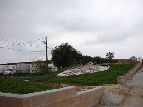 1993 Ford Taurus - A truck and several trailers are visible in the background, parked near a building under a cloudy sky.