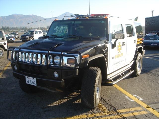 Hummer H2 SUV with sheriff markings, parked on asphalt