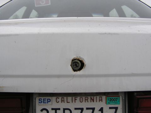 1986 Ford Tempo - '86 Ford Tempo Close up of rear trunk lid with a vandalized rear lock. A screwdriver is now the new key...