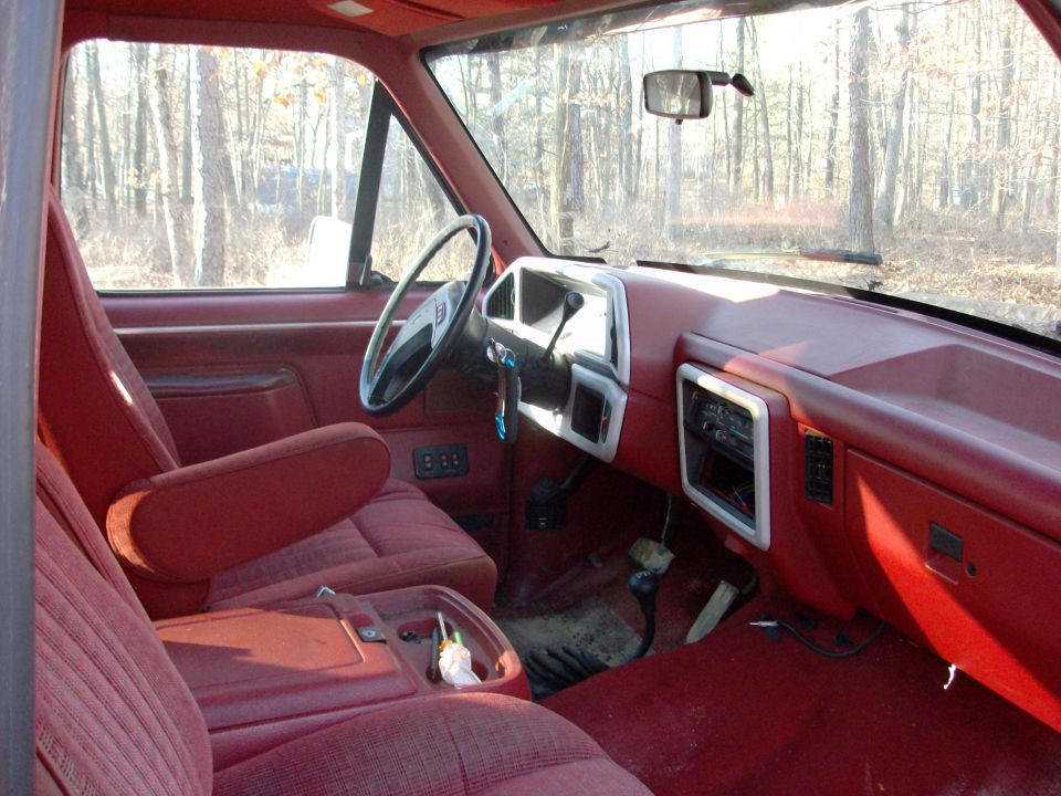 Red interior of a 1988 Ford Bronco, showing dashboard and seats