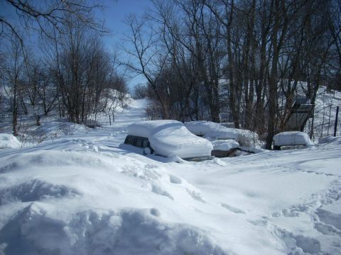 2000 Chevrolet Tahoe - Two vehicles are heavily covered in snow on a bright, clear winter day.