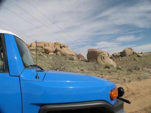 2007 Toyota FJ Cruiser - A blue Toyota FJ Cruiser is seen from the front quarter angle on a dirt road with large rock formations in the background.