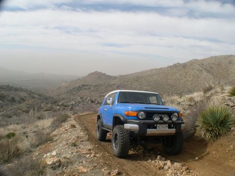 2007 Toyota FJ Cruiser - Blue 2007 Toyota FJ Cruiser navigates a rocky, dusty trail in a mountainous landscape.