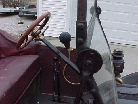 1913 Ford Model T - Close-up view of the driver's side interior of a vintage automobile, showing the steering column and controls.