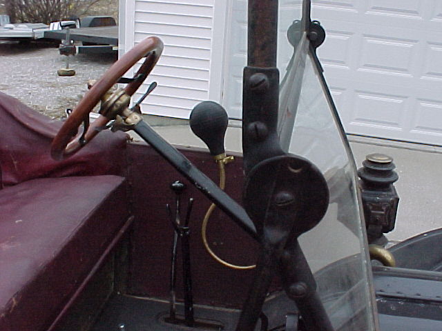 Steering wheel, floor pedals, and dashboard of an old car. A 'Supermotors.net' watermark is visible