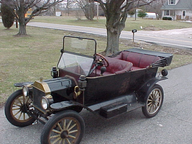 Black 1913 Ford Model T touring car with red upholstery, viewed from the front three-quarter angle