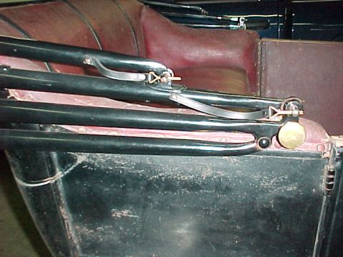 1913 Ford Model T - Close-up view of the interior of a 1913 Ford Model T, highlighting the red upholstery and black structural elements.