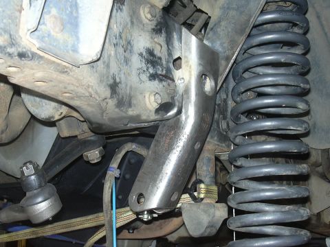1991 Ford Bronco - Undercarriage view showing a suspension component and coil spring, likely during modification or repair.