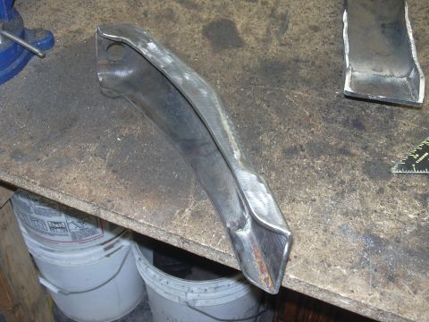 1991 Ford Bronco - A metal component rests on a workbench, showing signs of fabrication and wear.