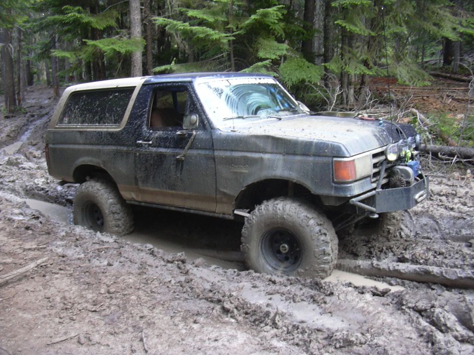 1991 Ford Bronco stuck in mud, off-road tires visible