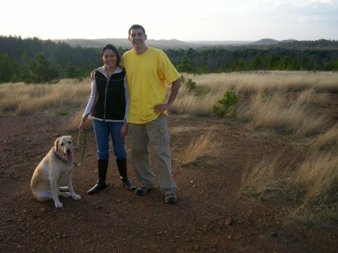 1993 Ford Bronco - A man, woman, and dog pose for a photo in a scenic outdoor location with rolling hills and dry grass.