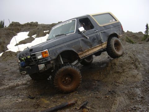 1991 Ford Bronco - This 1991 Ford Bronco is navigating a challenging off-road course on a cloudy day.