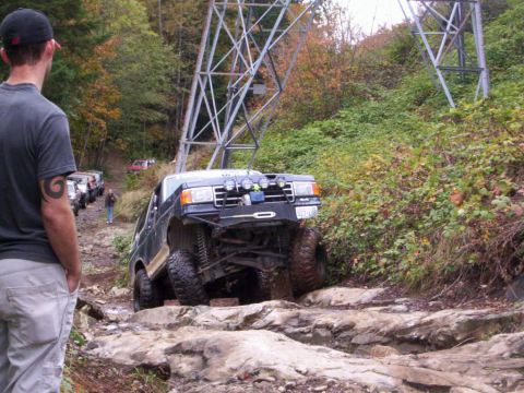 1991 Ford Bronco - Modified 1991 Ford Bronco tackling a challenging rocky obstacle on an off-road trail.