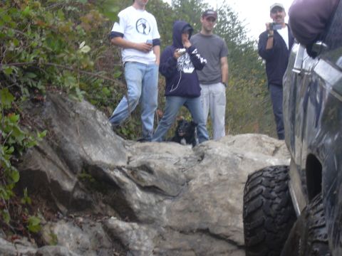 1991 Ford Bronco - People and off-road vehicles navigate a rocky terrain.