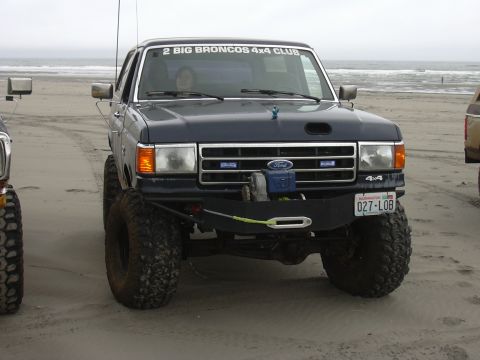 1991 Ford Bronco - This 1991 Ford Bronco, sporting a "2 BIG BRONCOS 4x4 CLUB" sticker, is seen on the beach with another vehicle nearby.