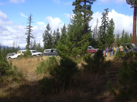 1991 Ford Bronco - Group of off-road vehicles gathered on a hillside during an event.