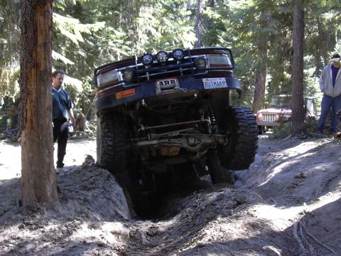 1991 Ford Bronco - This 1991 Ford Bronco is navigating a challenging off-road trail with steep inclines and ditches.