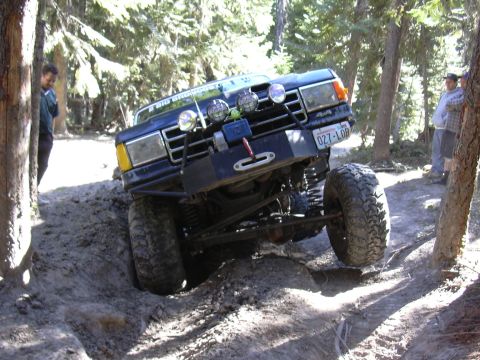 1991 Ford Bronco - This modified 1991 Ford Bronco tackles a challenging off-road trail, demonstrating its impressive suspension and tire grip.