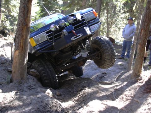 1991 Ford Bronco - This 1991 Ford Bronco is navigating a challenging off-road course with one wheel lifted.