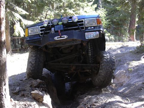 1991 Ford Bronco - This modified 1987 Ford Bronco tackles a challenging off-road obstacle with its front wheels high off the ground.