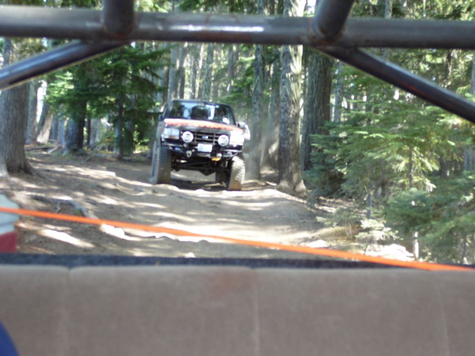 Orange off-road vehicle on a forest trail, front view