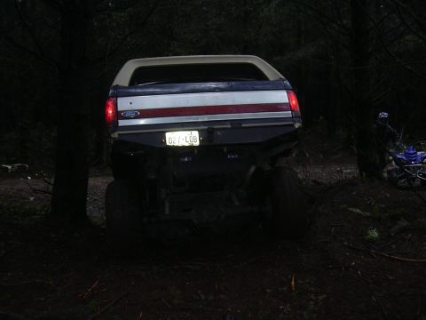 1991 Ford Bronco - Rear view of a 1991 Ford Bronco with a custom bumper, parked off-road near an ATV.