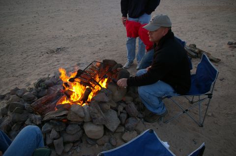 1986 Ford Bronco - Campfire scene with people cooking food on a grill.